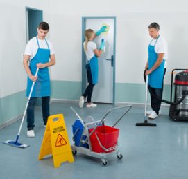 Group Of Janitors Cleaning Corridor With Cleaning Equipments